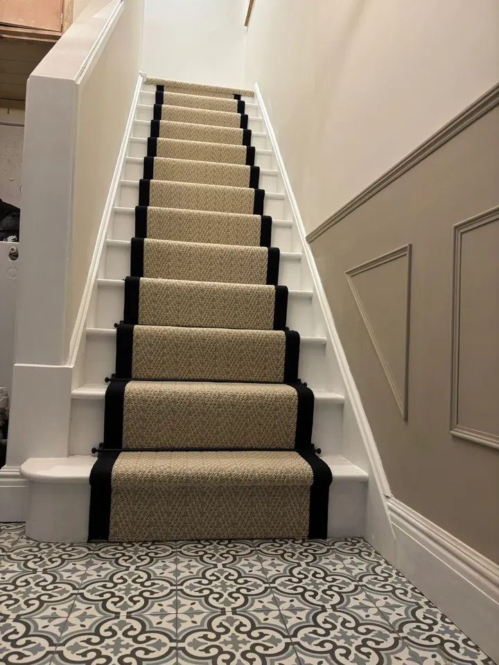 A carpet stair runner fitted with a dark border