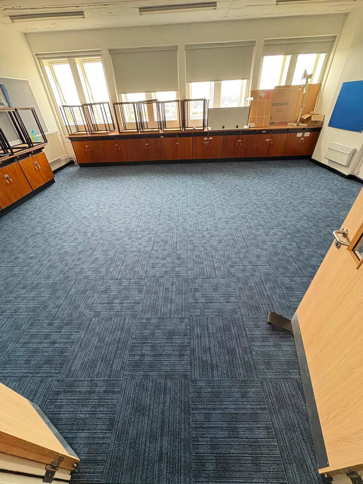 Blue carpet tiles fitted across a classroom floor