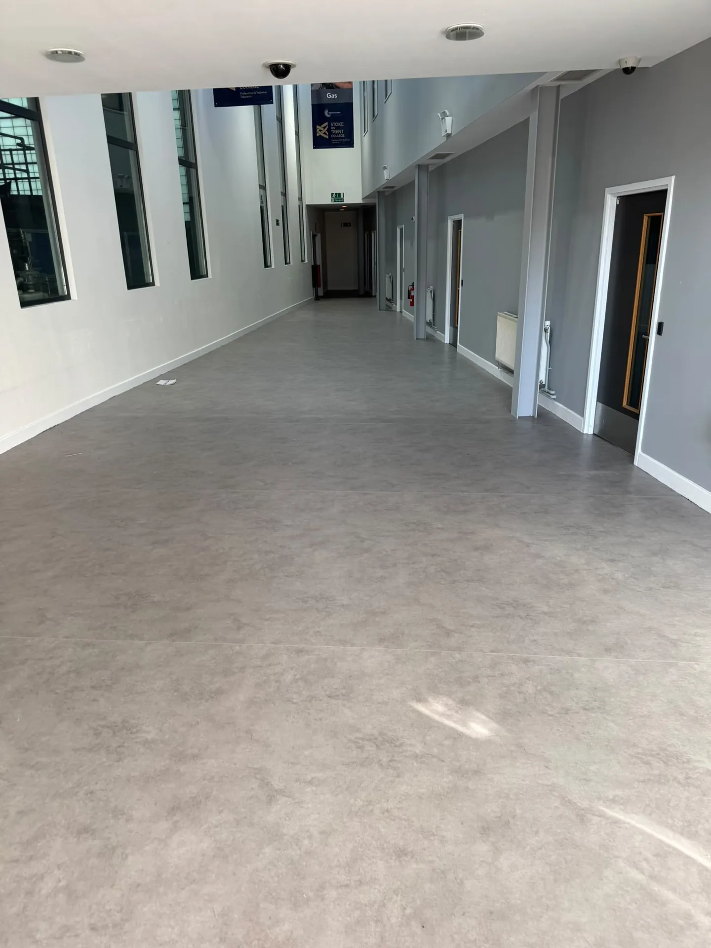 Grey flooring fitted in a bright shared corridor